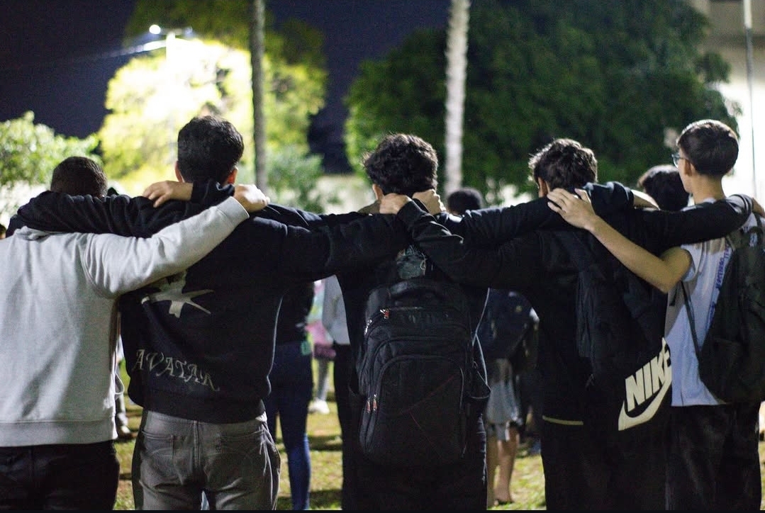 Jovens abraçados de costas durante encontro na rua