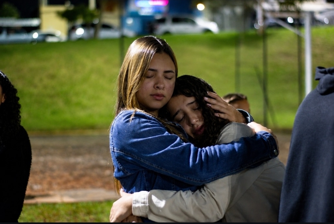 Duas jovens se abraçando emocionadas no encontro