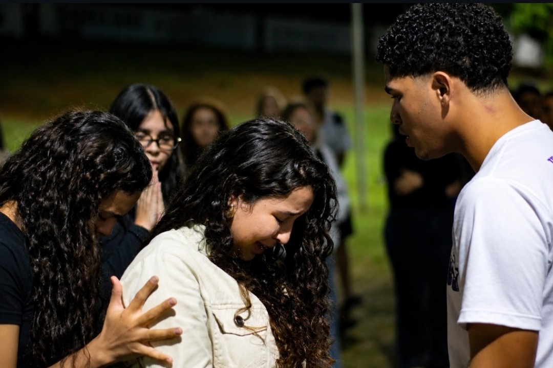 Grupo de jovens orando juntos à noite